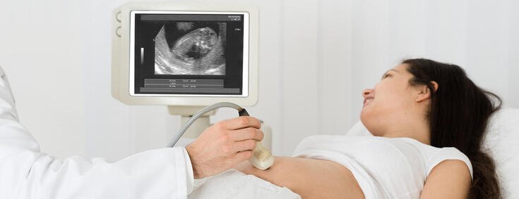 Frau bekommt Ultraschall-Untersuchung beim Frauenarzt