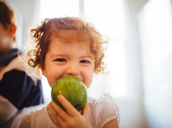 Kind mit Apfel im Mund