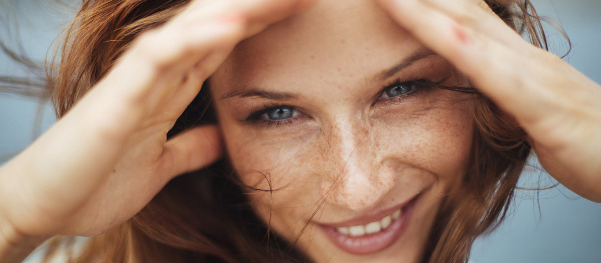 frau lächelt und fährt sich durch die haare