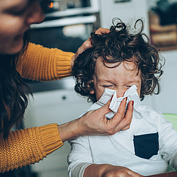 Mutter putzt ihrem Sohn die Nase.