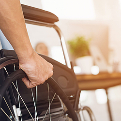 Ein Ausschnitt einer Person im Rollstuhl.