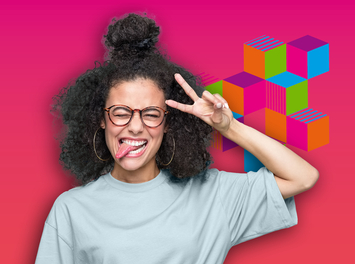 Eine junge Frau mit langen lockigen Haare und Brille lacht frech in die Kamera. Sie streckt ihre Zunge heraus und bildet das Peace-Zeichen, indem sie ihren Zeige- und Mittelfinger zu einem "V" ausstreckt.