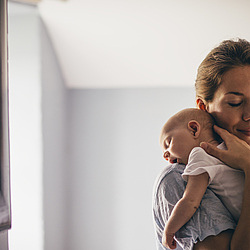 Frau mit Baby auf dem Arm.