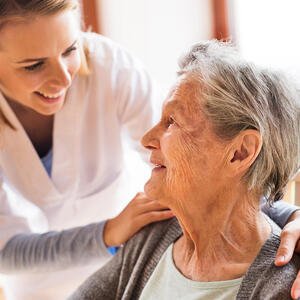 Krankenpflegerin kümmert sich um ältere Patientin