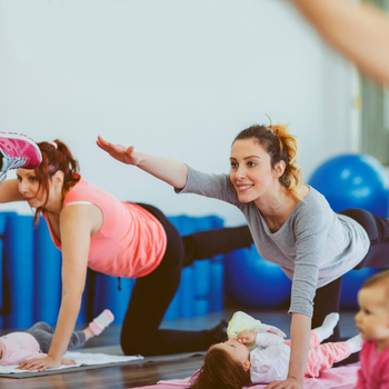 Eine Gruppe junger Mütter besucht einen Sportkurs. Die Mütter haben ihre Babys dabei.