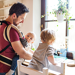 Vater macht den Abwasch zusammen mit zwei Kindern.