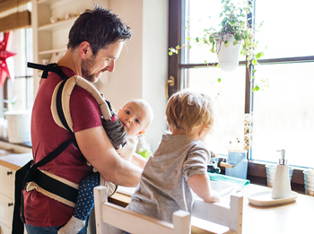 Vater macht den Abwasch mit zwei Kindern