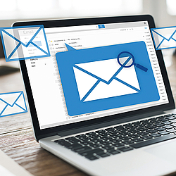 Auf dem Laptop-Display sind ein E-Mail-Programm und mehrere ungeöffnete Briefumschläge zu sehen.