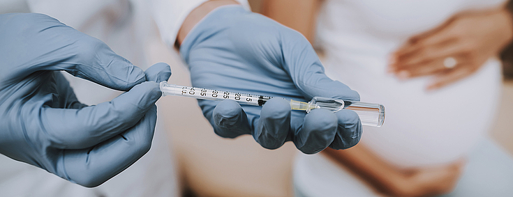 Impfungen Arzt füllt Spritze mit dem Impfstoff