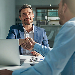 Zwei Männer sind bei einem Geschäftstreffen und geben sich die Hand.