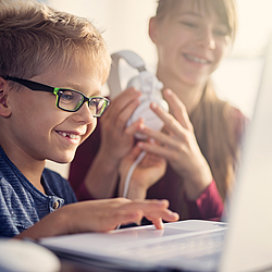 Kind mit Brille vor Laptop