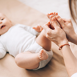 Frau massiert Fuß von Baby