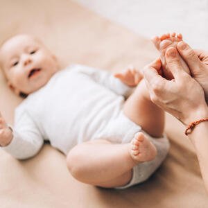 Frau massiert Fuß von Baby