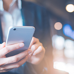 Eine Frau schaut auf ihr Smartphone.