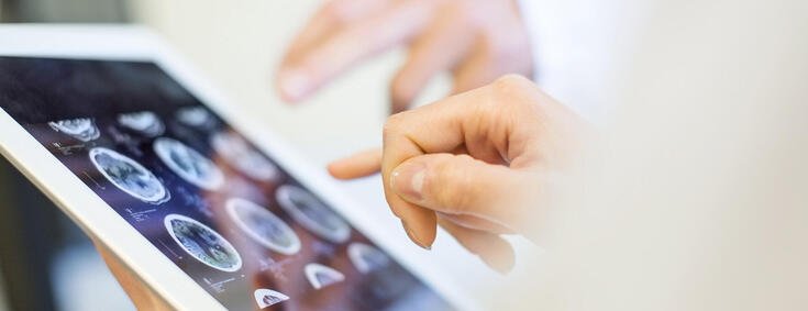 Ärzte schauen sich Röntgenaufnahmen auf Tablet an