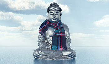 Eine Buddha-Statue. Sie steht auf dem Wasser, im Hintergrund sieht man einen blauen Himmel voller Wolken. Sie Statue trägt einen karierten Schal.