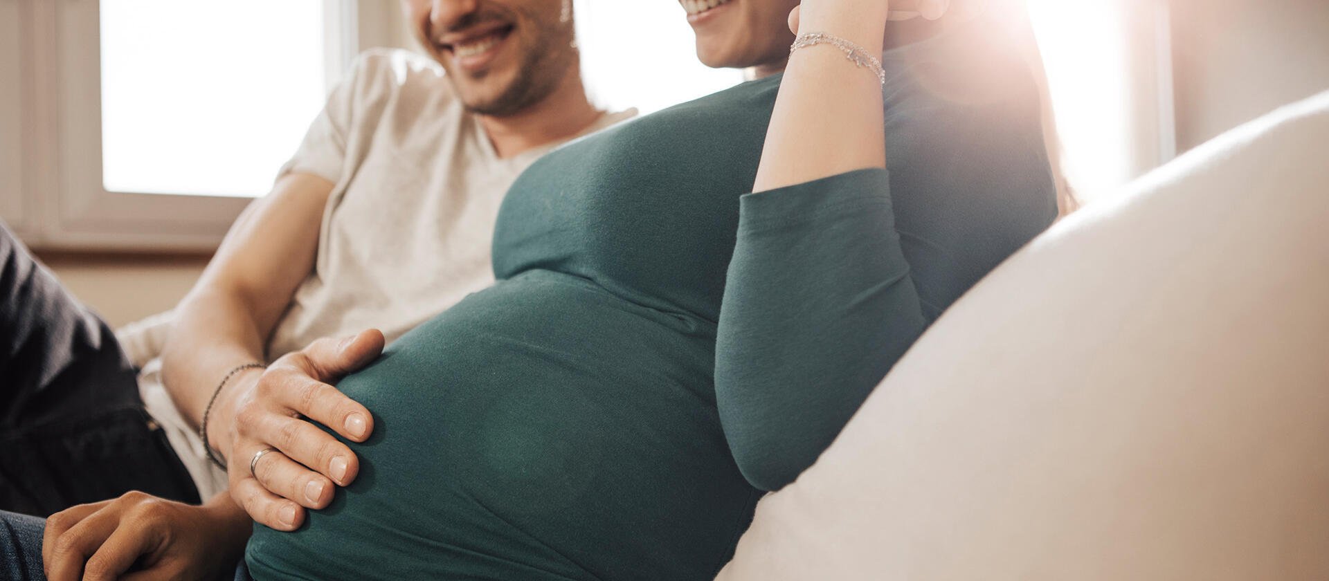 Paar glücklich Mann legt Hand auf schwangeren Bauch