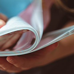 Eine Person blättert in einem Magazin.