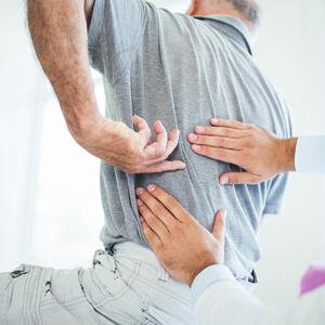 Osteopath behandelt Mann mit Rückschmerzen