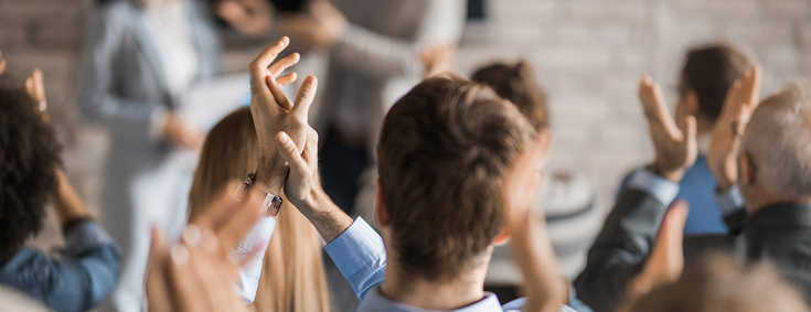 Publikum applaudiert Sprecher beim Seminar