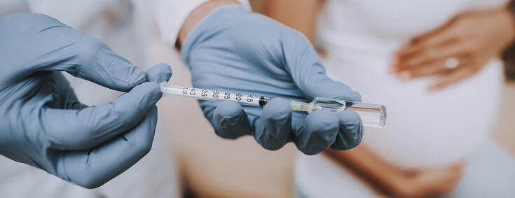 Arzt füllt Spritze mit dem Impfstoff