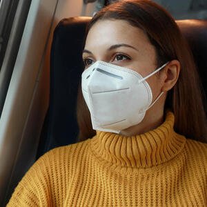 Frau mit FFP2-Maske im Zug