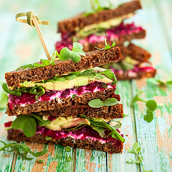 Ein gesundes Brot belegt mit Avocado, Salat und roter Beete.