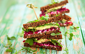 Ein gesundes Brot belegt mit Avocado, Salat und roter Beete.