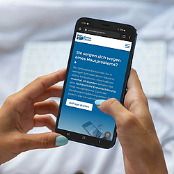Eine Frau nutzt ihr Smartphone. Sie stellt eine Anfrage bei "Online Doctor".