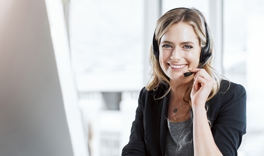 frau mit headset vor bildschirm